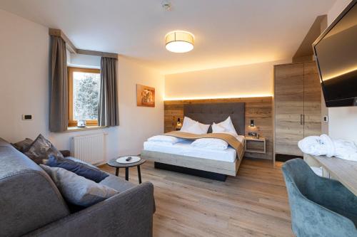维皮泰诺顿内尔瓦尔德勒酒店的一间卧室配有一张床和一张沙发