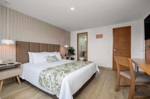 麦德林艾菲尼特公寓式酒店的配有一张床、一张桌子和一张桌子的酒店客房