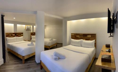长滩岛El Puerto Boracay Shore的一间卧室配有两张带白色床单的床