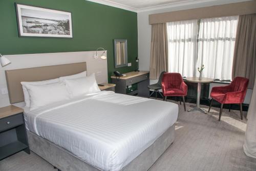 伯恩茅斯Park Inn by Radisson Bournemouth的酒店客房带一张床、一张桌子和椅子
