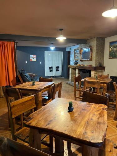 埃博森HOSTEL PEHUENIA的用餐室配有木桌和椅子