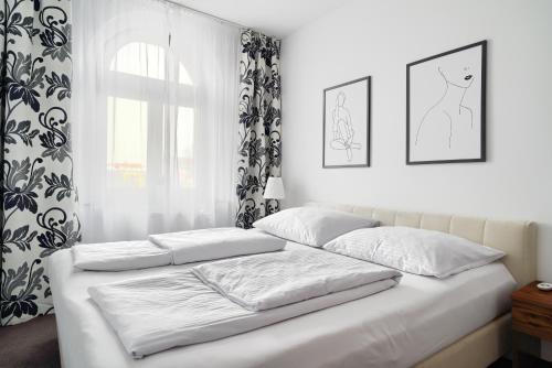 海乌姆诺APARTAMENT PRZY RYNKU II的一张带两个枕头的白色床和窗户