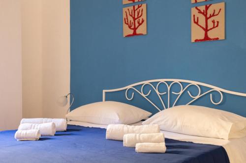 兰佩杜萨B&B La Rosa Lampedusa的蓝色卧室,配有带毛巾的床