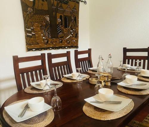 OuoranLa Villa Tila的木桌,带盘子、碗和餐巾