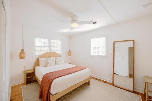 来特斯维比奇The Bungalow Loft by WB Abodes的白色卧室配有床和镜子