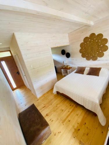 皮奇勒姆Forest house Cabaña para 2的卧室配有白色的床,铺有木地板