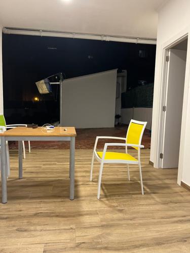 巴塞罗那La Meridian II的一张桌子和两把椅子以及投影屏幕