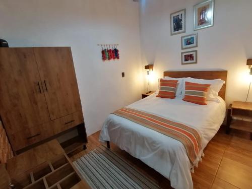 圣克里斯托瓦尔-德拉斯卡萨斯Suites del Barrio的一间卧室配有一张大床和一个木制橱柜