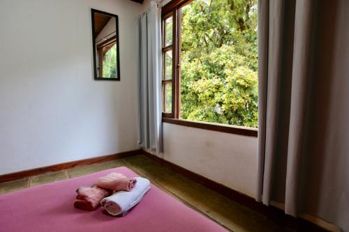 阿布拉奥Casa Matatiso - quartos privados em casa compartilhada的一张带粉红色毯子的床,位于一个窗户的房间