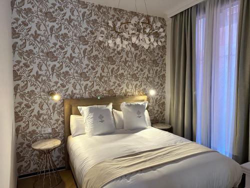 格拉纳达Bubaqia House - Suites Boutique的一间卧室配有一张带花卉壁纸的床