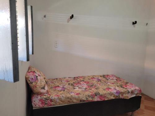 蒂鲍Casa em Tibau RN.的一张位于带花卉沙发的房间内的床铺