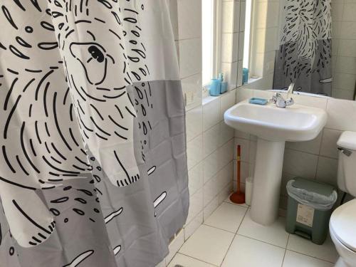普琼卡维DEPARTAMENTO MARAVILLOSA VISTA A JARDINES BAHIA PELICANOS的浴室设有斑马淋浴帘和水槽