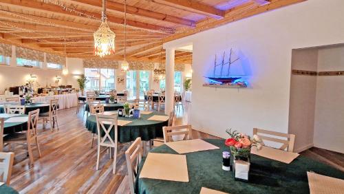 库瑞尼卡慕斯卡Doliva Park的一间设有桌椅的餐厅,墙上有一条船