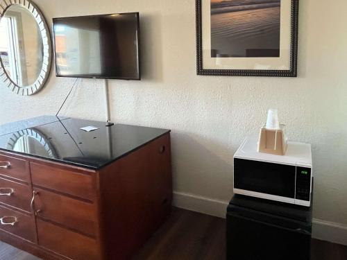 加尔维斯敦Motel 6 Galveston, TX Seawall的客房设有一个配备了微波炉和镜子的梳妆台
