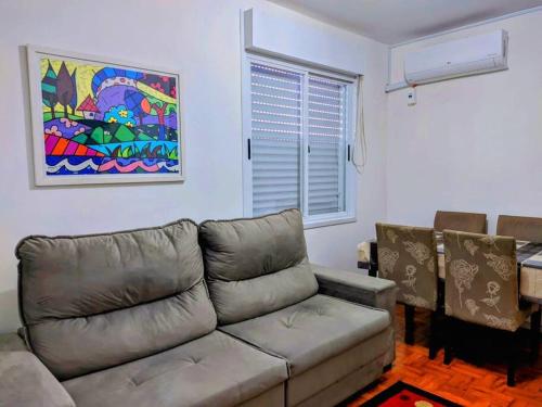 阿雷格里港Charmoso apartamento próximo ao Consulado EUA的客厅配有沙发和墙上的绘画