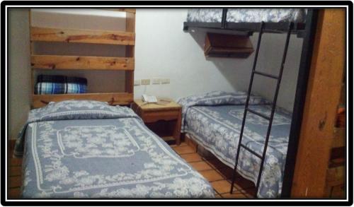 维多利亚城Hostal de Escandón的一间卧室配有两张双层床和一张书桌