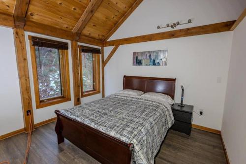 FairleePanoramic Mountain views w/hot tub, hiking trail的一间带一张床的卧室,位于带木制天花板的房间内