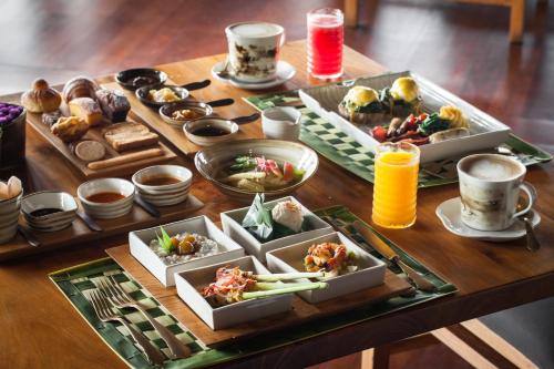 乌鲁瓦图宝格丽巴厘岛度假别墅酒店的一张木桌,上面放着食物和饮料