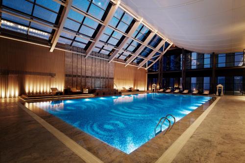 苏州苏州希尔顿酒店的一座大型游泳池,位于一座带窗户的建筑内