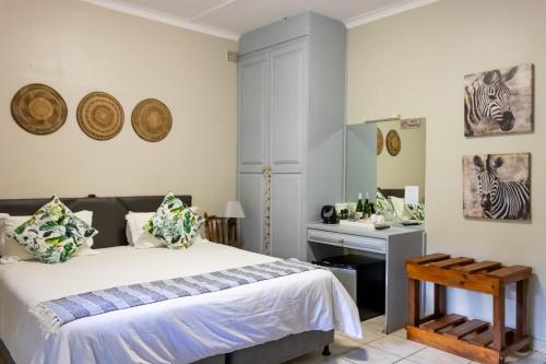 圣卢西亚African Dreamz Guest House的一间卧室配有一张床、一张书桌和一面镜子