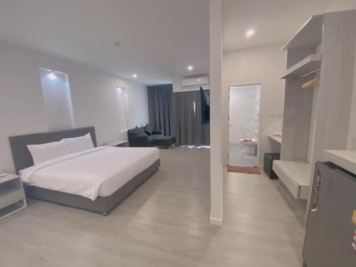 南奔GRAND PA Hotel&Resort Lamphun Chiang Mai的一间带白色床的卧室和一间浴室