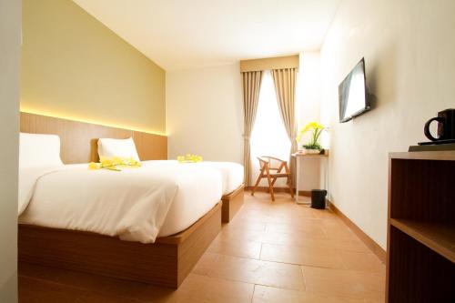 CurupSepanak Hotel by Amazing的酒店客房设有两张床和窗户。