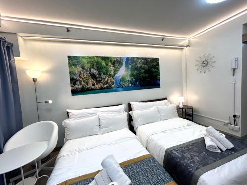 马尼拉Shore Residences MOA Dynastel Staycation的墙上画画的房间里设有两张床