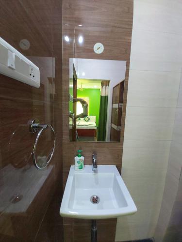 斯里卡拉哈斯蒂KSR GRAND的浴室设有白色水槽和镜子