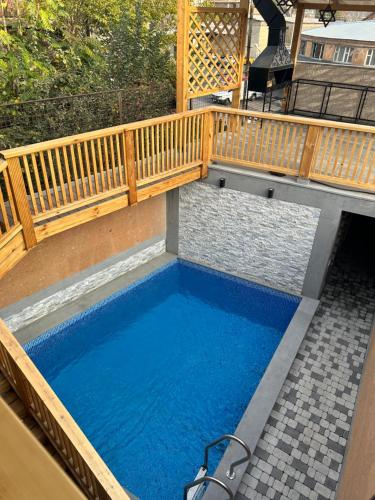 埃里温V.MOD Hotel的一个带木甲板和蓝色水的小游泳池