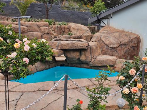 埃斯特科特The Haven: Make our Home your Home的花园中的游泳池,在岩石瀑布上放着一只猫