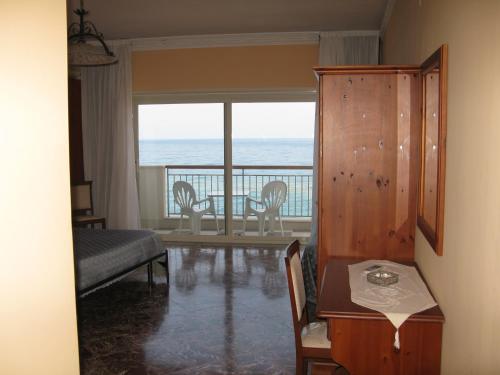 贾迪尼-纳克索斯哥斯达阿祖拉酒店的客厅配有桌子,享有海景