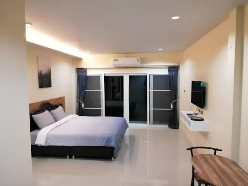 邦涛海滩Triple J Hometel的卧室配有白色的床和电视。