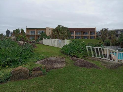 爱德华港Glenmore Sands Beach Resort的一座带白色围栏和建筑的院子