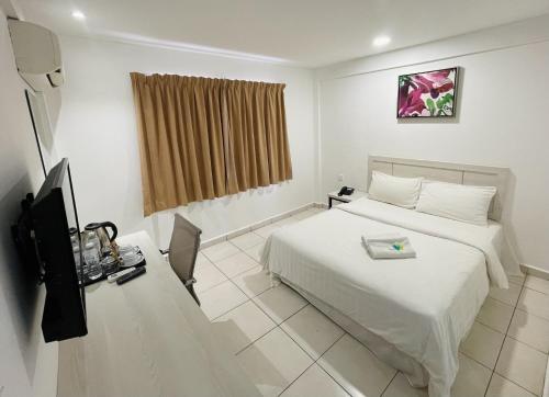 马六甲De Ocean Hotel的酒店客房,配有床和电视