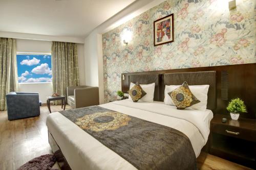 新德里Hotel Venus Plaza的一间卧室设有一张带花卉墙壁的大床