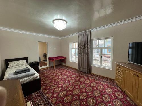 布哈拉Minorai Xurd的一间卧室配有一张床,铺有红色地毯