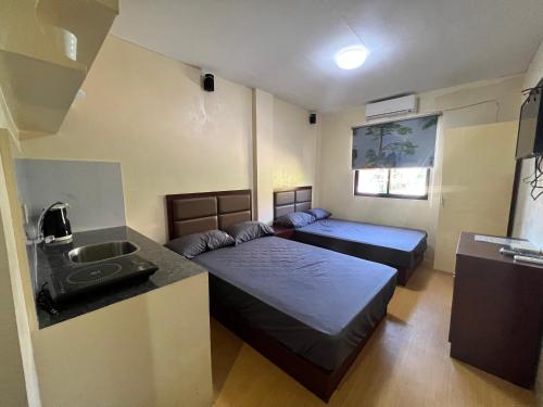 长滩岛APARTELLE BORACAY的小房间设有两张床和盥洗盆
