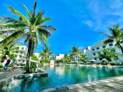 富国Larosa Hotel的棕榈树和建筑度假村的游泳池