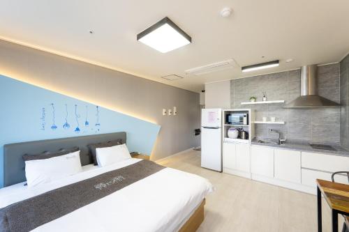 丽水市Yeosu View Foret Pension的一间带大床的卧室和一间厨房