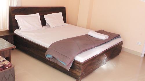 西姆拉Lakshay Regency的一间卧室配有一张木架大床