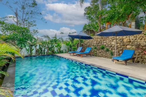 珀尼达岛Bhavana Cottage的一个带2把蓝色椅子和遮阳伞的游泳池