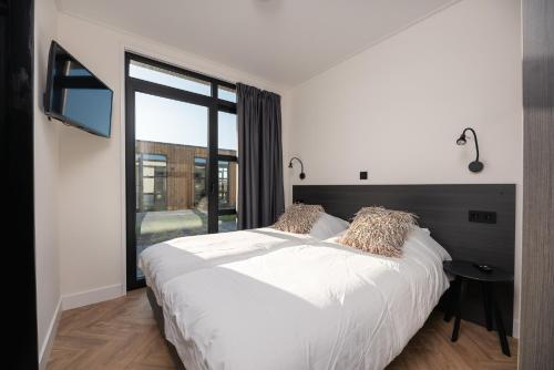 洛斯德雷赫特MarinaPark Residentie Nieuw Loosdrecht的卧室设有白色的床和大窗户