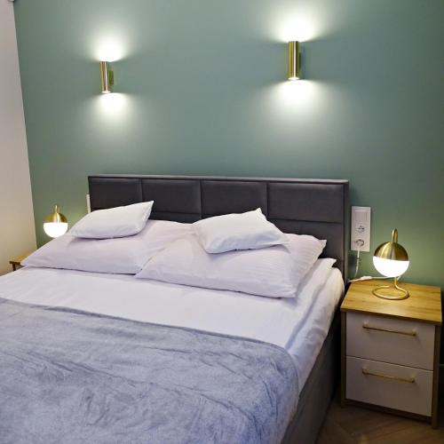 耶莱尼亚古拉Apartamenty u ROXI的卧室配有一张带两盏灯的墙壁床。