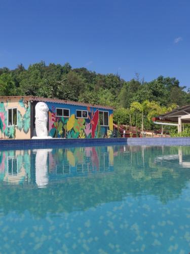浦那VRISA Mountain Retreat的一座水池,一座涂鸦的建筑