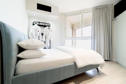 巴特亚姆Sweet Love - דירה מהממת על הים עם נוף的卧室配有带枕头的床铺和窗户。