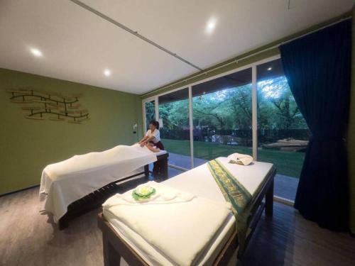 Ban Khlong SonChillax Luxury Pool Villa - Koh Chang的坐在带两张床的房间的女人