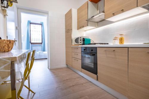 蒙扎Cozy Apartment in Monza City Center的厨房配有木制橱柜和炉灶烤箱。