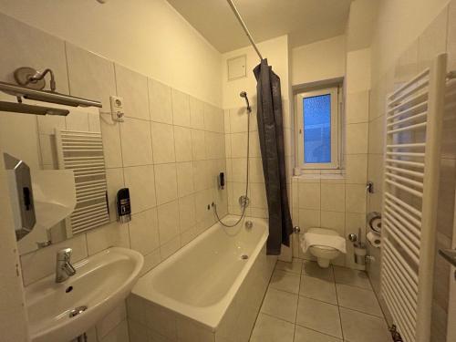 美因河畔法兰克福WestEnd#206的带浴缸、盥洗盆和卫生间的浴室