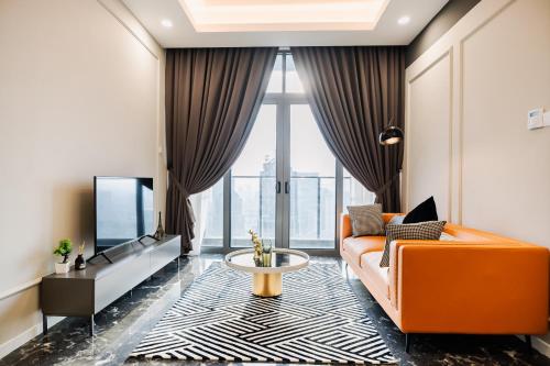 吉隆坡Royce KLCC Kuala Lumpur City Centre by Dormeo Destinations的客厅配有橙色沙发和电视