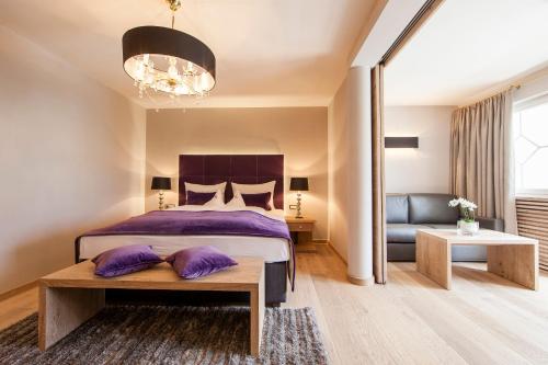 纳图尔诺Sonnen Resort的一间卧室配有一张带紫色枕头的床和一张沙发